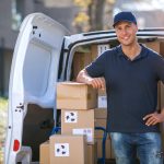 Smiling,Delivery,Man,Standing,In,Front,Of,His,Van